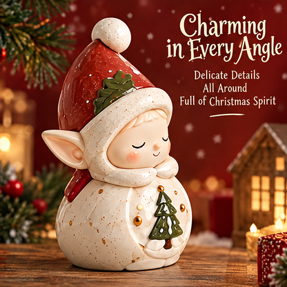 Angled view of the Christmas elf showing pointed ears, a green tree motif, gold-tone accents and a red hat.